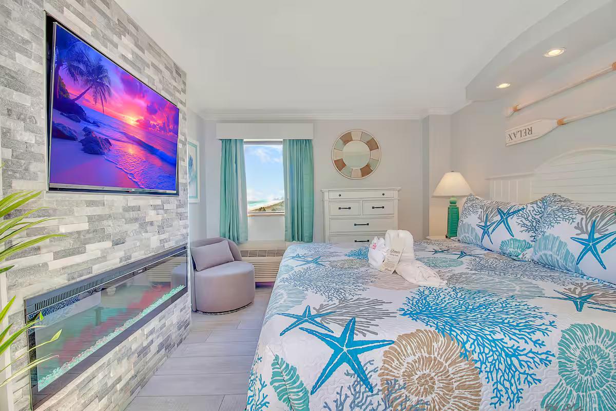 Coastal bedroom with stone fireplace accent wall